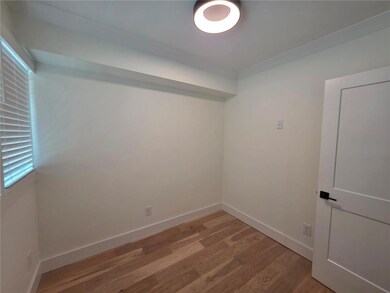 Unfurnished room with light wood-style flooring and baseboards