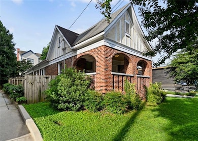 View of side of home featuring brick siding and covered porch