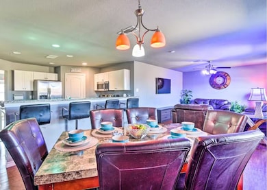 Dining room with recessed lighting, wood finished floors, a ceiling fan, and a chandelier