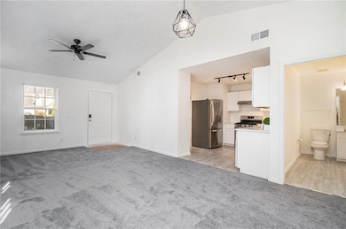 Unfurnished living room featuring lofted ceiling, 