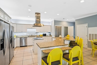 Kitchen featuring stainless steel appliances, island exhaust hood, a sink, a large island, and light tile patterned flooring