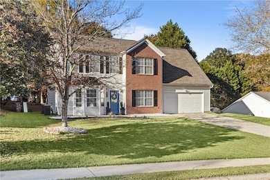 View of front of home with concrete driveway, a front lawn, roof with shingles, a garage, and brick siding