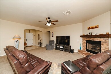 Carpeted living room featuring ceiling fan and a f