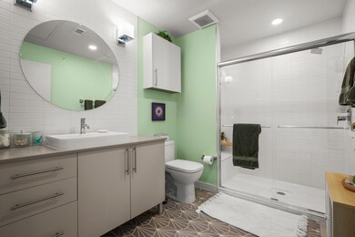 Full bath featuring vanity, a shower stall, tile 