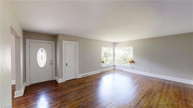 Large living room featuring a picture window, new paint and newly refurnished hardwood floors.