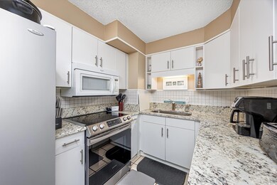 Kitchen with light stone countertops, appliances w