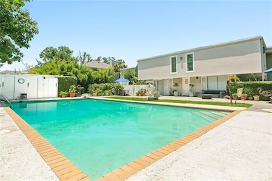 Pool behind brick privacy fence entering to the ho
