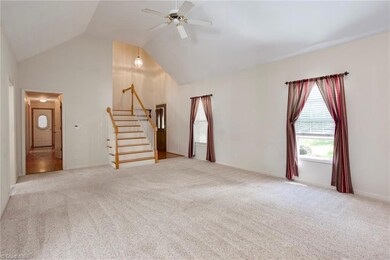 Oversized living room has cathedral ceiling and gas log fireplace.