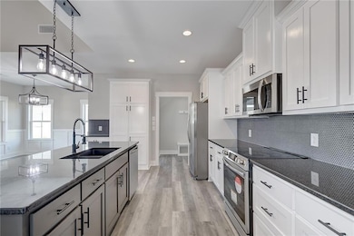 Kitchen featuring sink, white cabinetry, a center 