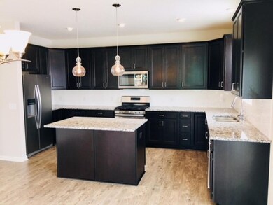 Beautiful kitchen with dark cabinets, granite coun