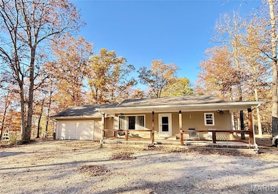 Ranch-style house featuring covered porch, driveway, and an attached garage