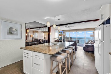 Kitchen with ceiling fan, white cabinetry, a cente