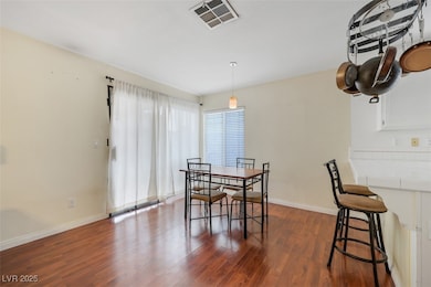 Dining room with dark wood-style flooring and baseboards