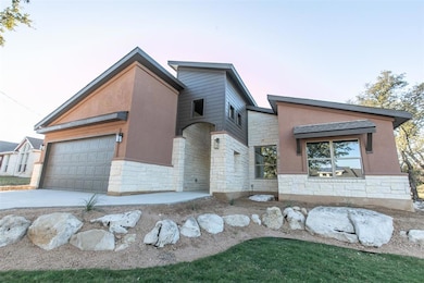 View of front of home featuring stone siding, a g