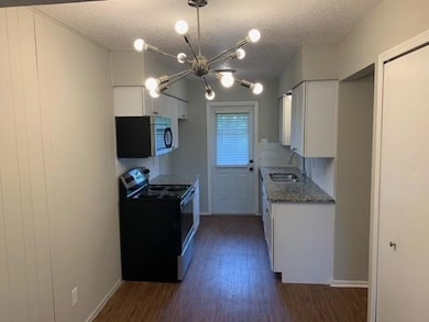 Kitchen with a textured ceiling, a sink, stainless