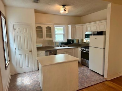 Kitchen featuring white cabinets, appliances with