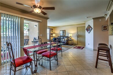 Tiled dining area with crown molding, a ceiling fa