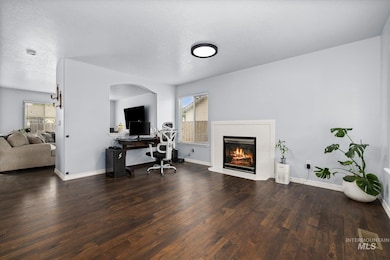 Office featuring healthy amount of natural light, a textured ceiling, dark wood-style floors, and a tile fireplace