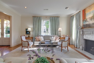 Living area with crown molding, french doors, wood finished floors, a fireplace, and recessed lighting