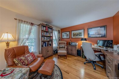 The home office has French doors and hardwood floors.