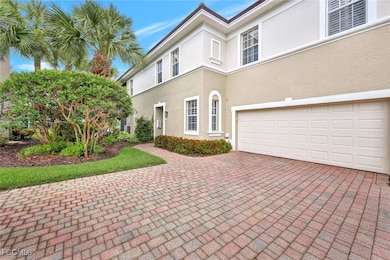 View of front facade featuring a garage, stucco siding, and decorative driveway