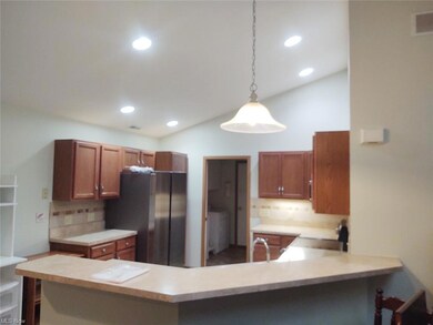Kitchen with brown cabinets, light countertops, ha
