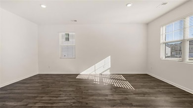 Unfurnished room with dark wood-style floors, plenty of natural light, and recessed lighting