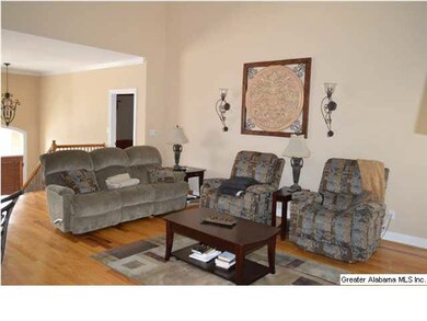 Open concept living room boasts vaulted ceiling, fireplace, ceiling fan, and hardwoods.