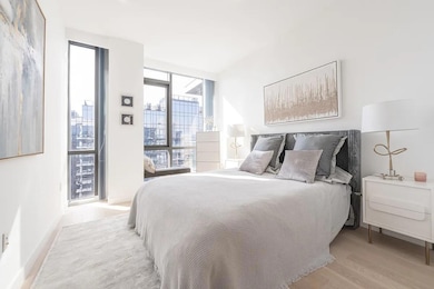 Bedroom featuring floor to ceiling windows and light wood-style floors