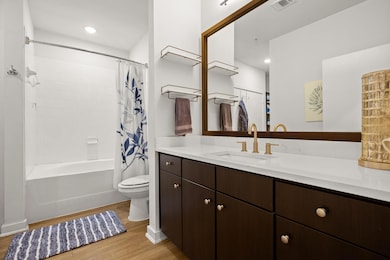Full bath featuring wood finished floors, vanity,