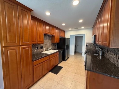 Kitchen with stainless steel microwave, dark ston