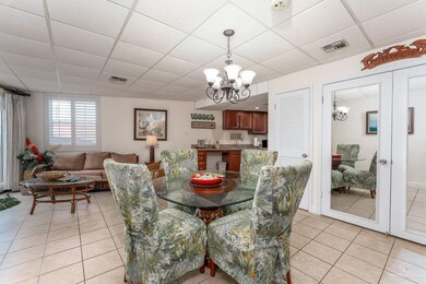 Dining area featuring an inviting chandelier, light tile patterned floors, a paneled ceiling, and visible vents