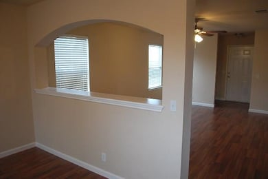 Hallway with dark wood-type flooring and arched w