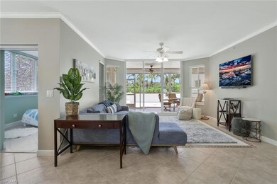 Tiled living room featuring crown molding, ceiling fan, healthy amount of natural light, and baseboards