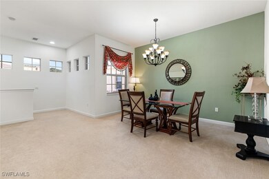 Carpeted dining area with a chandelier, recessed l