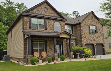 View of front of house featuring a porch, a front lawn, concrete driveway, and an attached garage