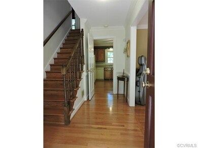 Welcoming foyer has wood floor and wood staircase.