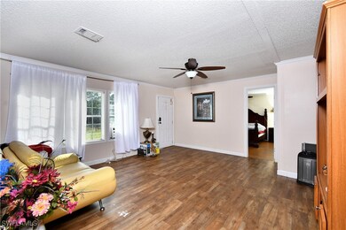 Sitting room with a textured ceiling, dark wood-ty
