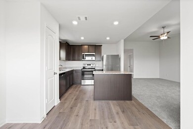 Kitchen with light wood-type flooring, dark brown 