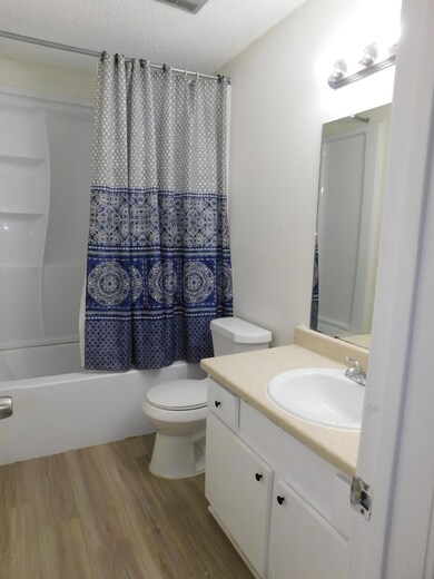 Full bathroom featuring wood finished floors, sho