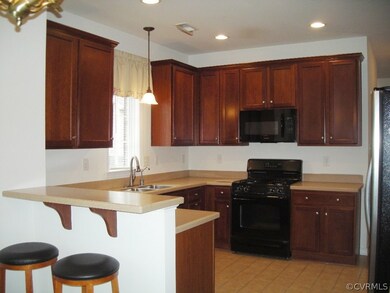 Kitchen has tile floor, breakfast bar, solid surface countertops and is eat in