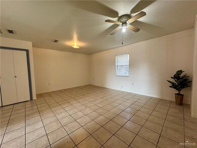 Empty room featuring light tile patterned flooring and ceiling fan
