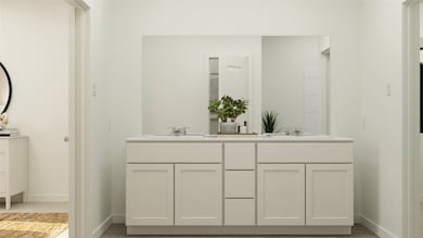 Full bathroom with double vanity and baseboards