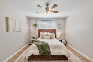 Large bedroom with ceiling fan with natural light