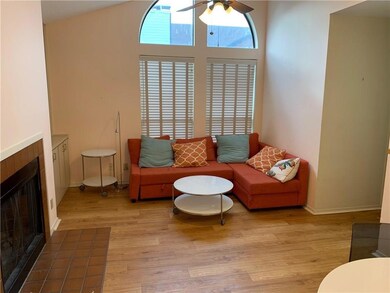 Living room with a tiled fireplace, ceiling fan, 