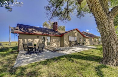 Rear view of property with a yard and a patio