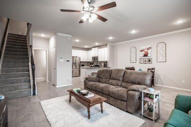 Living room with ceiling fan and ornamental molding