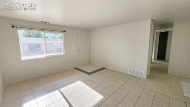 Unfurnished room with light tile patterned floors and baseboards