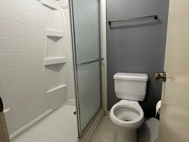 Bathroom with a stall shower and tile patterned floors