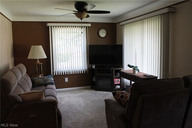 Carpeted living room with ceiling fan